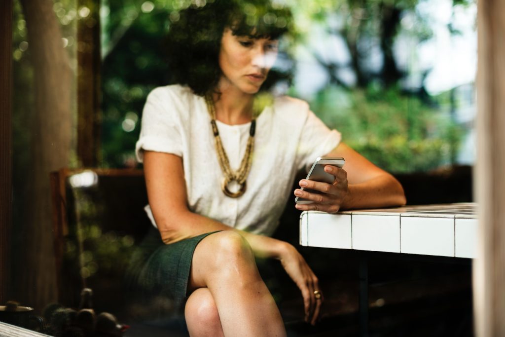 A woman looks at her phone in preparation for GDPR's affect on programmatic advertising.